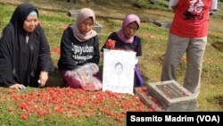 Pendamping, keluarga korban dan korban saat berziarah sambil melakukan tabur bunga di TPU Pondok Ranggon, Jakarta, Senin, 13 Mei 2019. (Foto: Sasmito Madrim/VOA)