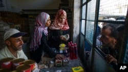 People queue outside a shop that just opened after the breach of blockade in Deir el-Zor, Syria, Sept. 15, 2017. 