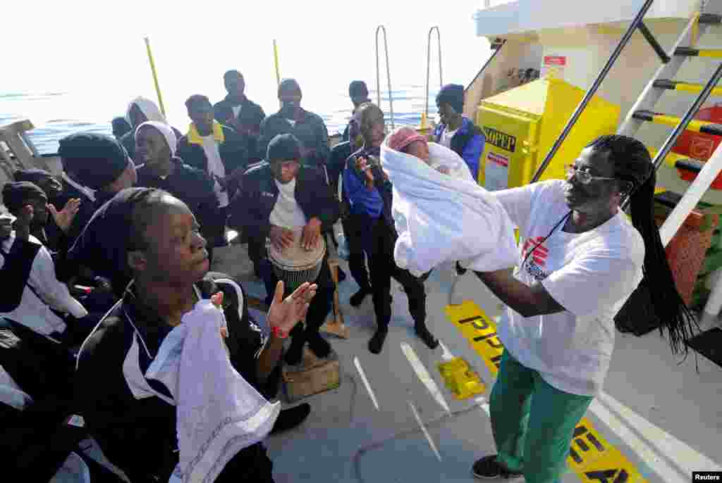 Migrants dance and sing to celebrate the birth of Miracle, a baby who was born on board the Aquarius, in the central Mediterranean Sea, May 26, 2018.