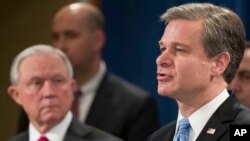 Attorney General Jeff Sessions listens as FBI Director Christopher Wray speaks during a news conference about the arrest of Cesar Sayoc, 56, of Aventura, Fla., in the package bomb case, at the Department of Justice, Oct. 26, 2018, in Washington. 