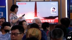 韩国火车站乘客观看大屏幕电视，正播放朝鲜发射导弹节目（2019年7月31日）