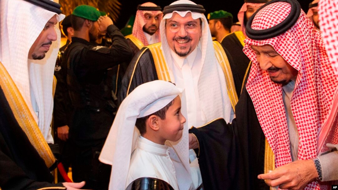 FILE - In this photo released by Saudi Press Agency, SPA, Saudi King Salman greets a boy during his visit to Qassim province in Qassim, Saudi Arabia, Nov. 7, 2018.
