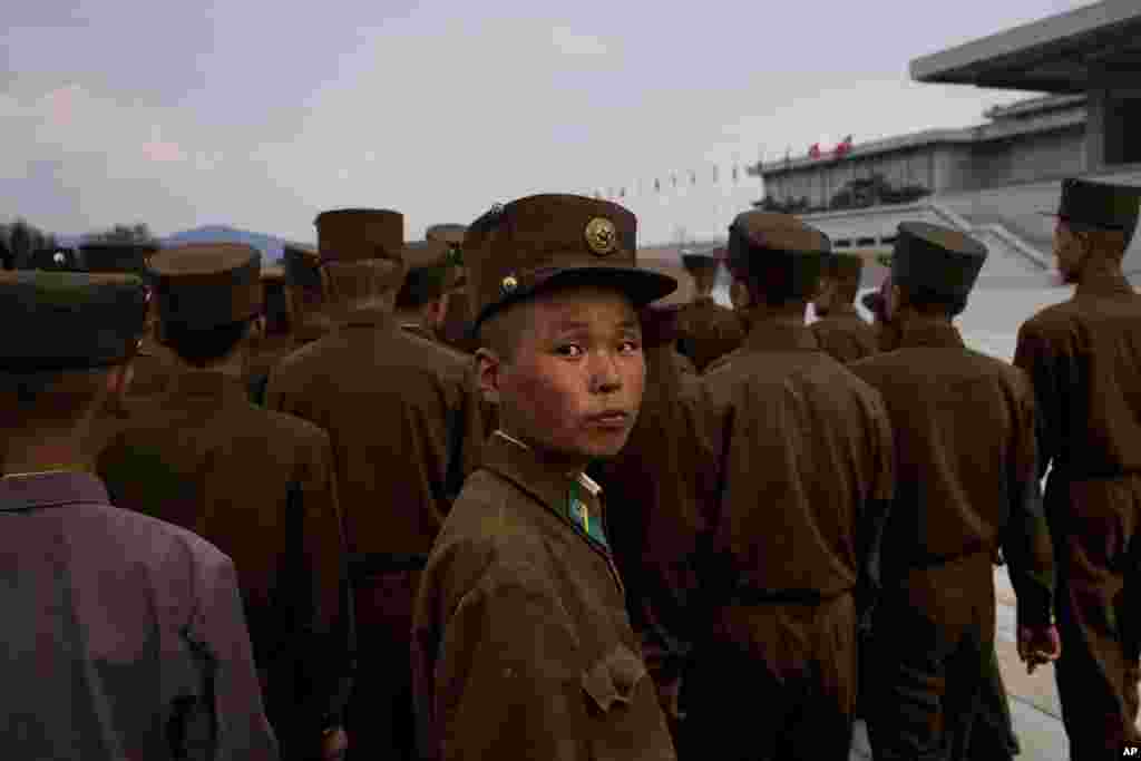 North Korean soldiers and civilians pose for souvenir photos in front of a fountain as they tour the grounds of Kumsusan Palace of the Sun, Pyongyang, April 25, 2013.