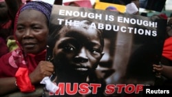 A woman holds a sign during a protest demanding the release of abducted secondary school girls from the remote village of Chibok, in Lagos, May 5, 2014. 
