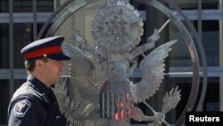 FILE - A police officer patrols the United States embassy in Ottawa, Canada.