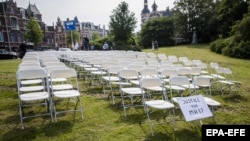 NETHERLANDS -- White chairs and a placard are set up by relatives of crash victims of flight MH17 as a silent protest in front of the Russian embassy in The Hague, May 8, 2018