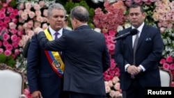 El nuevo presidente de Colombia, Iván Duque, recibe la banda presidencial del presidente del Senado, Ernesto Macías, durante su ceremonia de inauguración en la Plaza Bolívar, en Bogotá, Colombia, el 7 de agosto de 2018. REUTERS / Carlos Garcia Rawlins -