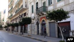 A picture taken Nov. 17, 2013, shows a man walking past closed shops in the Libyan capital Tripoli. 