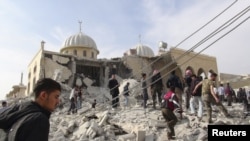 Cư dân và các thành viên của Quân đội Giải phóng Syria tại đền thờ Hồi giáo Bilal bị hư hại sau vụ pháo kích của chính phủ Syria, ngày 24/10/2012
