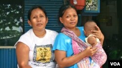 Santi with her four-month-old son and neighbor. The 26-year-old mother says she cannot afford birth registration for her children, Jakarta, Indonesia, March 2, 2013. (K. Lamb/VOA)