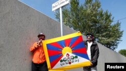 活動人士在中國復旦大學計劃在匈牙利布達佩斯建立的分校附近被重新命名為“達賴喇嘛路”的路標旁亮出西藏旗幟。(2021年6月2日)