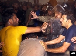 Iraqi riot police spray water and tear gas to prevent protesters from storming the provincial council building during a demonstration in Basra, 550 kilometers (340 miles) southeast of Baghdad, Iraq, May 21, 2016.