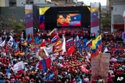 FILE - Supporters gather at Diego Ibarra Square to listen Venezuela's President Nicolas Maduro speak after a ceremony formalizing his candidacy for the upcoming presidential election, in Caracas, Venezuela, Feb. 27, 2018.