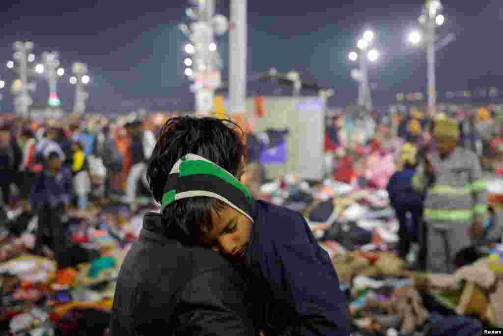 A Hindu devotee holds his son as they leave after a deadly stampede before the second Shahi Snan (royal bath) at the Maha Kumbh Mela, or the Great Pitcher Festival, in Prayagraj, India.