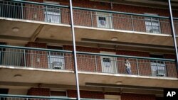 FILE - A students stands on the balcony of Ehringhaus dormitory on campus at the University of North Carolina in Chapel Hill, N.C., Aug. 18, 2020.