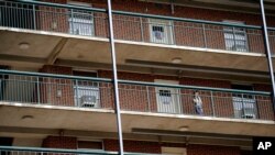 FILE - A students stands on the balcony of Ehringhaus dormitory on campus at the University of North Carolina in Chapel Hill, N.C., Aug. 18, 2020. 