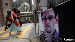 A poster supporting Edward Snowden, a former contractor at the National Security Agency who leaked revelations of U.S. electronic surveillance, is displayed at Hong Kong's financial Central district June 17, 2013.