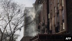 FILE - Smoke billows out of a building at the scene of a fire in Johannesburg on August 31, 2023.