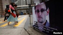 A poster supporting Edward Snowden, a former contractor at the National Security Agency who leaked revelations of U.S. electronic surveillance, is displayed at Hong Kong's financial Central district June 17, 2013.