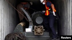 Panama forensic workers work in a container holding a green missile-shaped object seized from the North Korean flagged ship "Chong Chon Gang" at the Manzanillo Container Terminal in Colon City, July 17, 2013. 