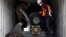 Panama forensic workers work in a container holding a green missile-shaped object seized from the North Korean flagged ship "Chong Chon Gang" at the Manzanillo Container Terminal in Colon City, July 17, 2013.