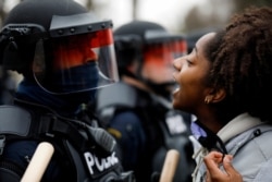 A demonstrator confronts police during a protest after police allegedly shot and killed a man, who local media report is identified by the victim's mother as Daunte Wright, in Brooklyn Center, Minnesota, U.S., April 11, 2021.