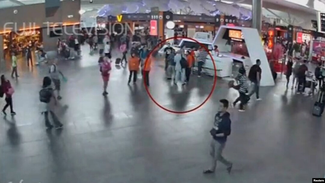 Potongan gambar CCTV menunjukkan pria yang diduga Kim Jong-nam (dilingkari merah) berbicara dengan petugas bandara setelah dihadang perempuan berkaos putih, di Bandar Udara Internasional Kuala Lumpur (13/2).