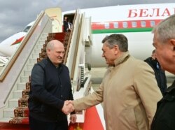 Belarusian President Alexander Lukashenko (L) is welcomed upon his arrival at a Moscow airport on April 22.