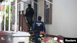 Para petugas Badan Penegak Imigrasi dan Bea Cukai mencari pelarian imigran gelap di Santa Ana, California, 11 Mei 2017.