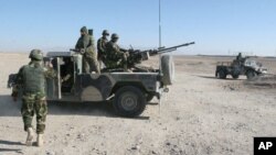 FILE - Afghan National Army soldiers stand guard at a checkpoint in Afghanistan, Dec. 23, 2015. The Taliban’s foreign minister says all those who were part of Afghan security forces prior to the Taliban takeover may not be part of the country's new military.