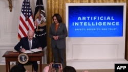 La vicepresidenta de EEUU, Kamala Harris, observa cómo el presidente Joe Biden, firma una orden ejecutiva para regular el avance del desarrollo y uso seguro y confiable de la inteligencia artificial, en la Casa Blanca, Washington, el 30 de octubre de 2023.