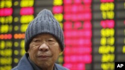 一名股票投資者在上海證券交易所的交易版顯示屏幕前。
