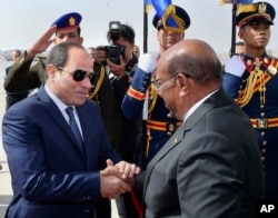 In this photo released by the Egyptian Presidency's office, Sudan's President Omar al-Bashir right, shakes hands with Egyptian President Abdel-Fattah El-Sissi in Cairo, Egypt, Jan. 27, 2019.