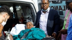 Somalia's government spokesperson Mohamed Ibrahim Moalimuu, who was injured at the scene of an explosion, is assisted for medical evacuation to Turkey at the Aden Abdulle Osman International Airport in Mogadishu, Somalia, Jan. 17, 2022.