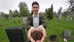 FILE - Katrina Spade, the founder and CEO of Recompose, a company that hopes to use composting as an alternative to burying or cremating human remains, poses for a photo in a cemetery in Seattle as she displays a sample of compost material left from the d