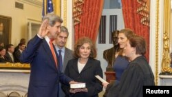 Former Senator and chairman of the Senate Foreign Relations Committee John Kerry (D-MA) is officially sworn-in as Secretary of State as his wife, Teresa Heinz Kerry (C) looks on in this handout photo release by the U.S. Senate Photographic Studio in Washi