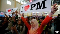 Malaysian Izzati Zaidi (R), 24, and her friends show placards in support of Malaysia's Prime Minister Najib Razak during the launch of the "Voices of My Generation" youth programme in Kuala Lumpur, April 12, 2013. 