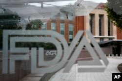 This Aug. 2, 2018, file photo shows the U.S. Food and Drug Administration building behind FDA logos at a bus stop on the agency's campus in Silver Spring, Md. (AP Photo/Jacquelyn Martin, File)