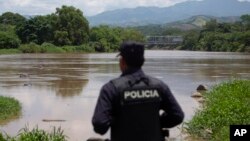 Un agente policial salvadoreño observa sobre el río La Paz en la frontera con Guatemala en La Hachadura, El Salvador, el jueves, 12 de septiembre, de 2019.