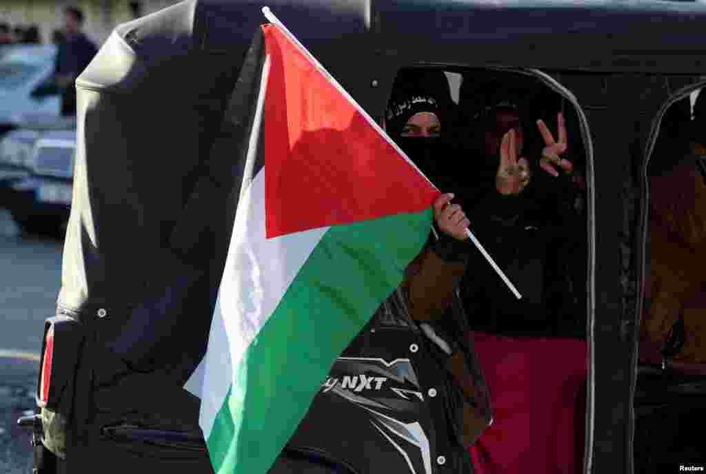 Una persona sostiene una bandera palestina mientras la gente celebra cerca del cruce fronterizo de Masnaa, después de que los rebeldes sirios anunciaran que habían derrocado al presidente Bashar al-Assad, Líbano, el 8 de diciembre de 2024.