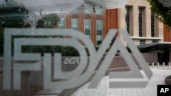 This Aug. 2, 2018, file photo shows the U.S. Food and Drug Administration building behind FDA logos at a bus stop on the agency's campus in Silver Spring, Md. (AP Photo/Jacquelyn Martin, File)