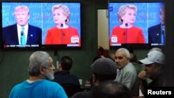 People watch the U.S. presidential debate in a restaurant in the Queens borough of New York City, Sept. 26, 2016. 