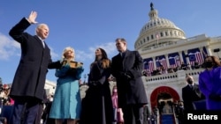 Joe Biden is sworn in as the 46th president of the United States by Chief Justice John Roberts as Jill Biden holds the Bible during the 59th Presidential Inauguration at the U.S. Capitol.