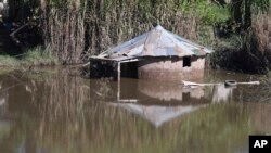 FILE - A home is submerged in flood waters near Durban, South Africa, Monday, May 23, 2022.