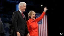 Mantan Presiden AS Bill Clinton dan isterinya, Hillary Rodham Clinton, kandidat capres dari partai Demokrat AS, melambaikan tangan kepada para pendukungnya pada malam penggalangan dana di Des Moines, Iowa (24/10).