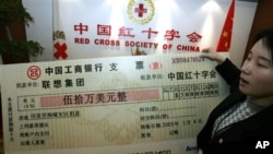 中國紅十字會的僱員舉著中國電腦公司聯想集團捐助的50萬美元支票的放大版本。（2005年1月4日)