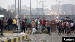 Opponents of deposed Egyptian president Mohamed Morsi throw stones at Morsi supporters in Cairo's Nasr City. (July 27, 2013)