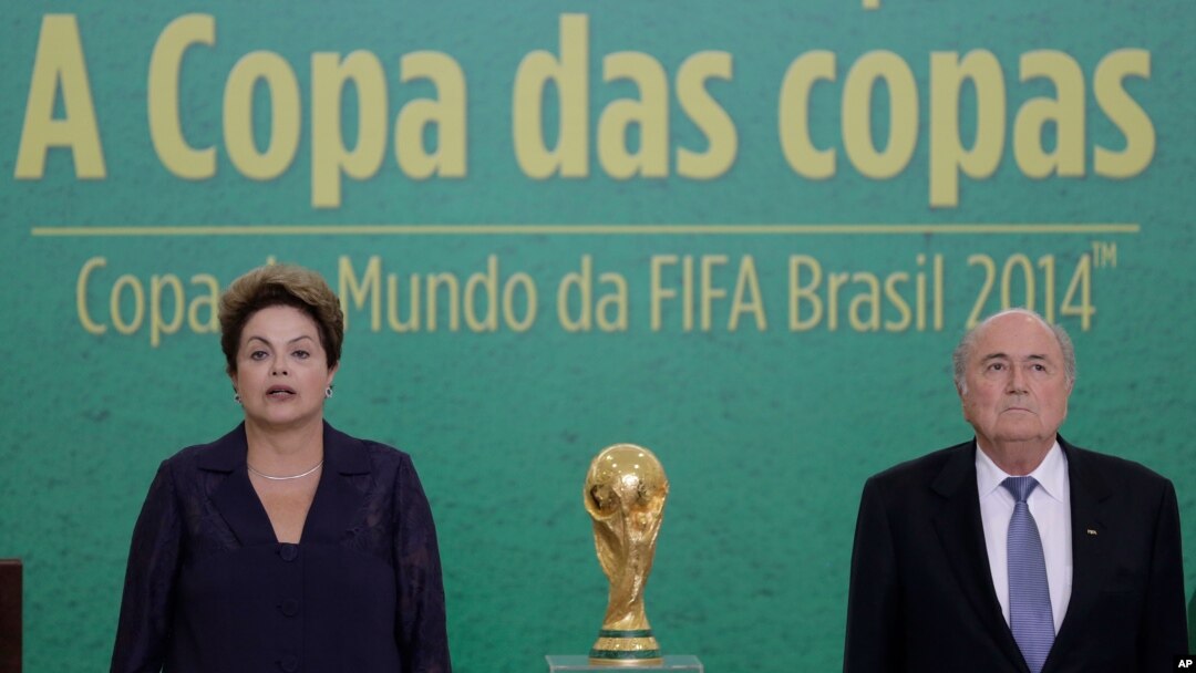 Presiden Brazil Dilma Rousseff (kiri) dan Presiden FIFA Joseph Blatter dalam upacara penyerahan trofi Piala Dunia 2014 di istana presiden Planalto di Brasilia, Brazil (2/6). (AP/Eraldo Peres)