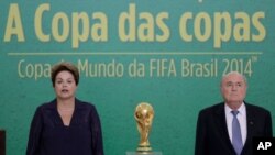 Presiden Brazil Dilma Rousseff (kiri) dan Presiden FIFA Joseph Blatter dalam upacara penyerahan trofi Piala Dunia 2014 di istana presiden Planalto di Brasilia, Brazil (2/6). (AP/Eraldo Peres)