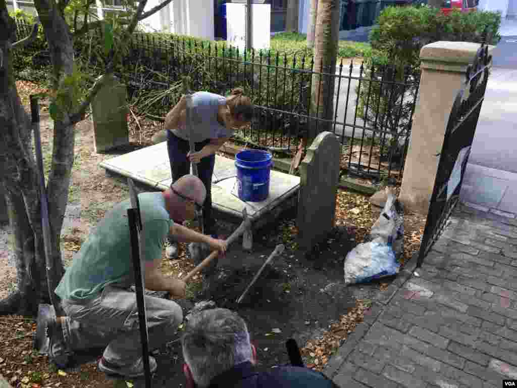 American College of the Building Arts student Leigh Yarbrough and her instructor Simeon Warren restore a tombstone, Charleston, S.C., Sept. 17, 2019. (J. Taboh/VOA News)